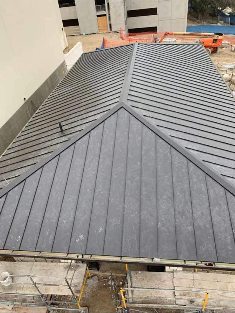 Commercial metal roof construction with crane equipment in Prospect Park